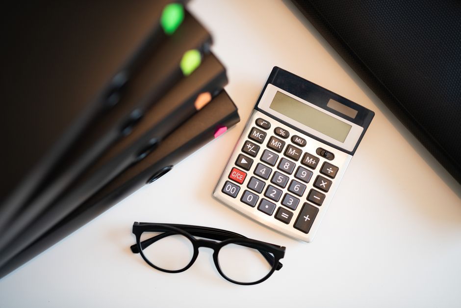 Calculator, glasses and folders on a desk ready for a home loan assessment