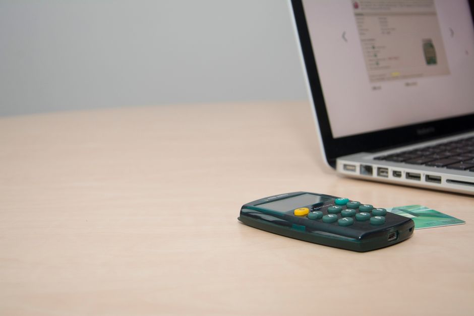 Credit cards beside a calculator and notepad on a desk