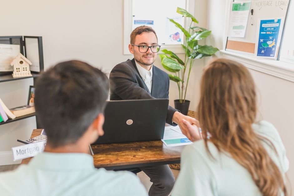 Mortgage broker going through loan documents with clients in an office