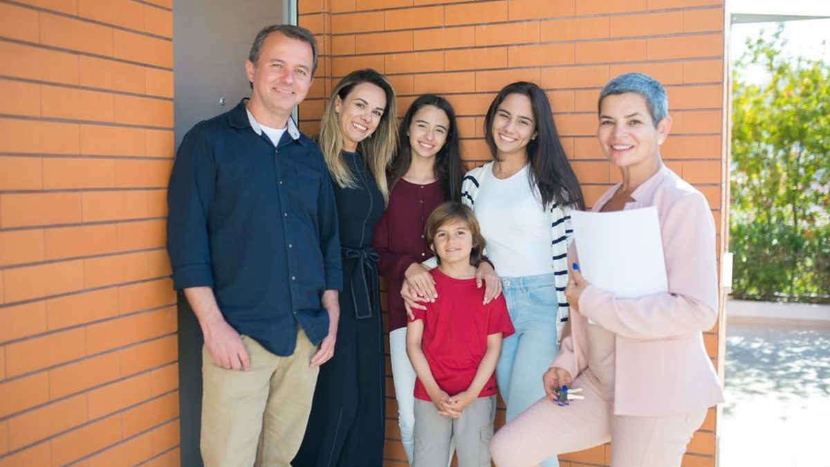 Family standing outside their new Australian home after settlement