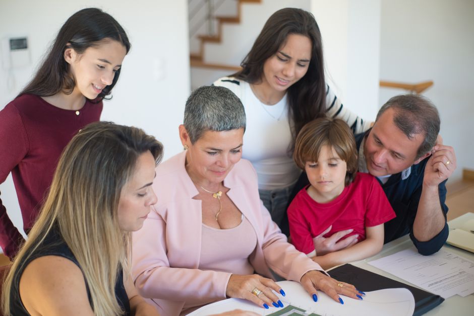 Parents and their adult child going through home loan paperwork at a kitchen table