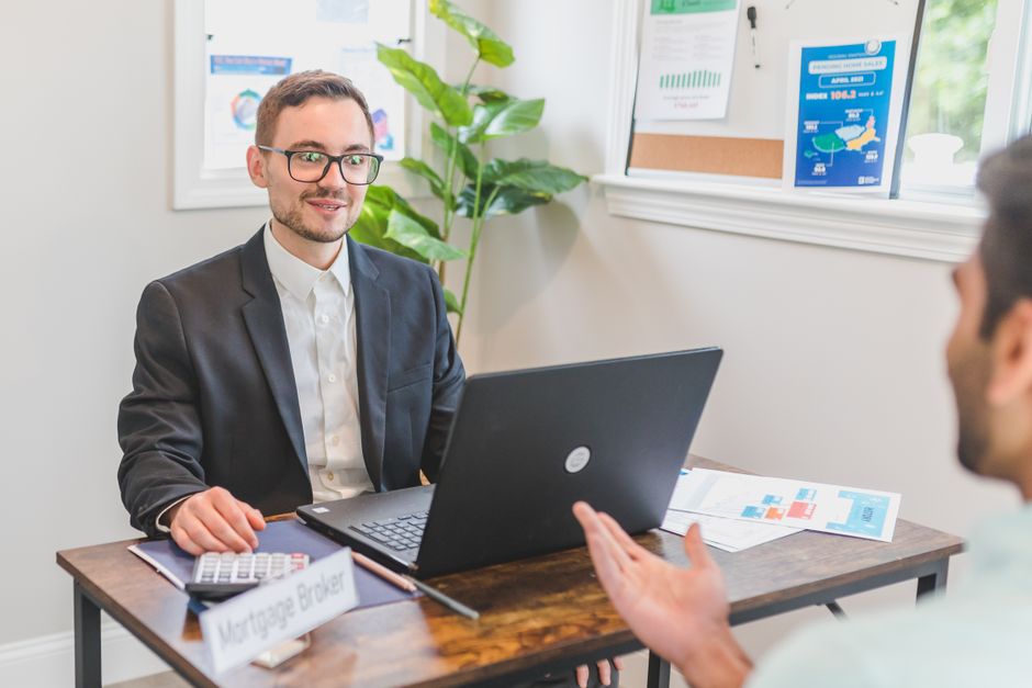Mortgage broker going through loan documents with clients at a desk