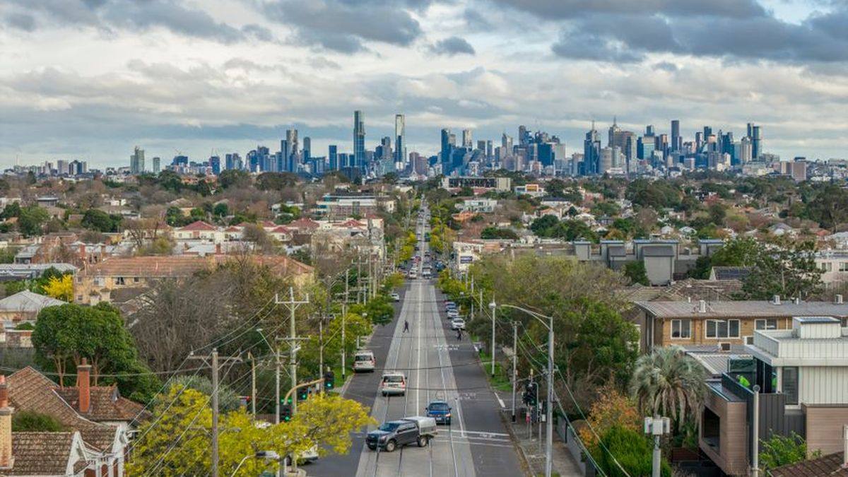 Melbourne skyline seen across suburban rooftops at dusk
