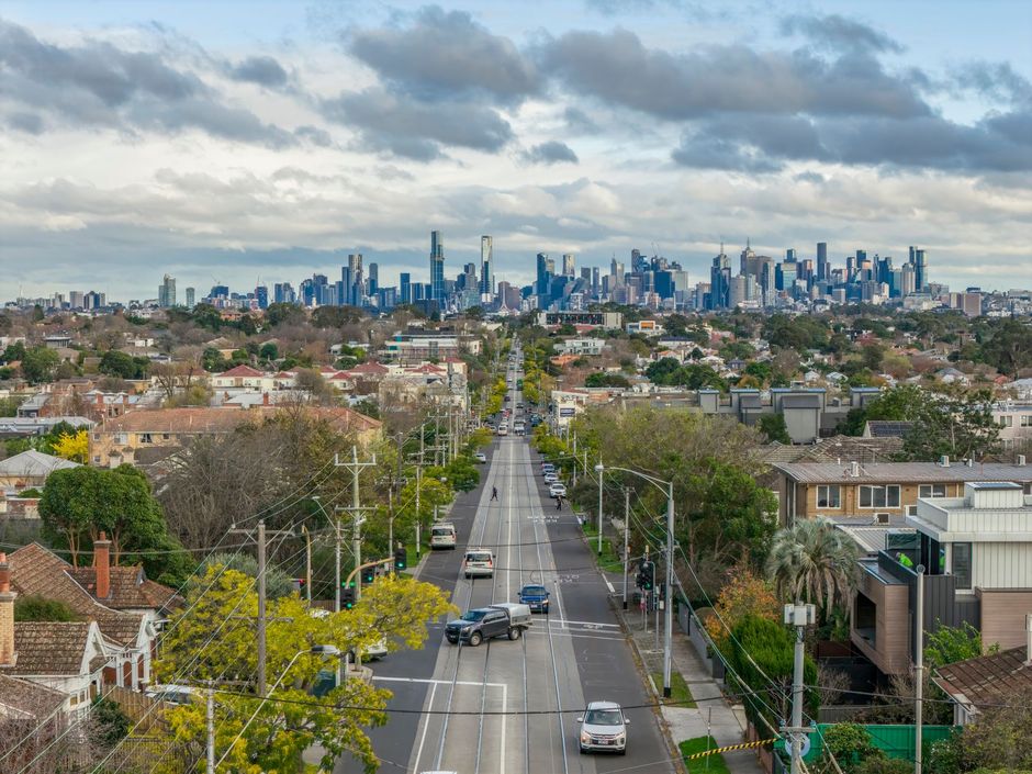 Aerial view of a Melbourne suburban street leading towards the city skyline