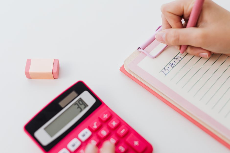 Calculator and notebook on a desk used to work out loan repayments