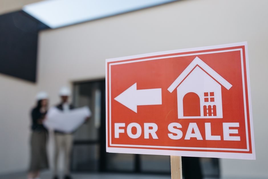 For sale sign outside an Australian house on a quiet suburban street