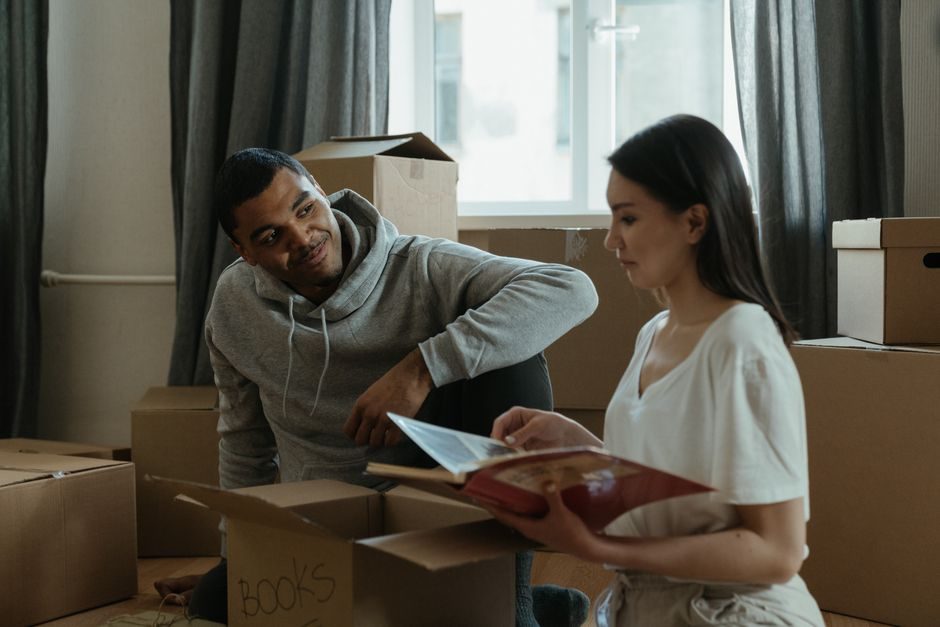 Couple carrying moving boxes into a new home after settlement